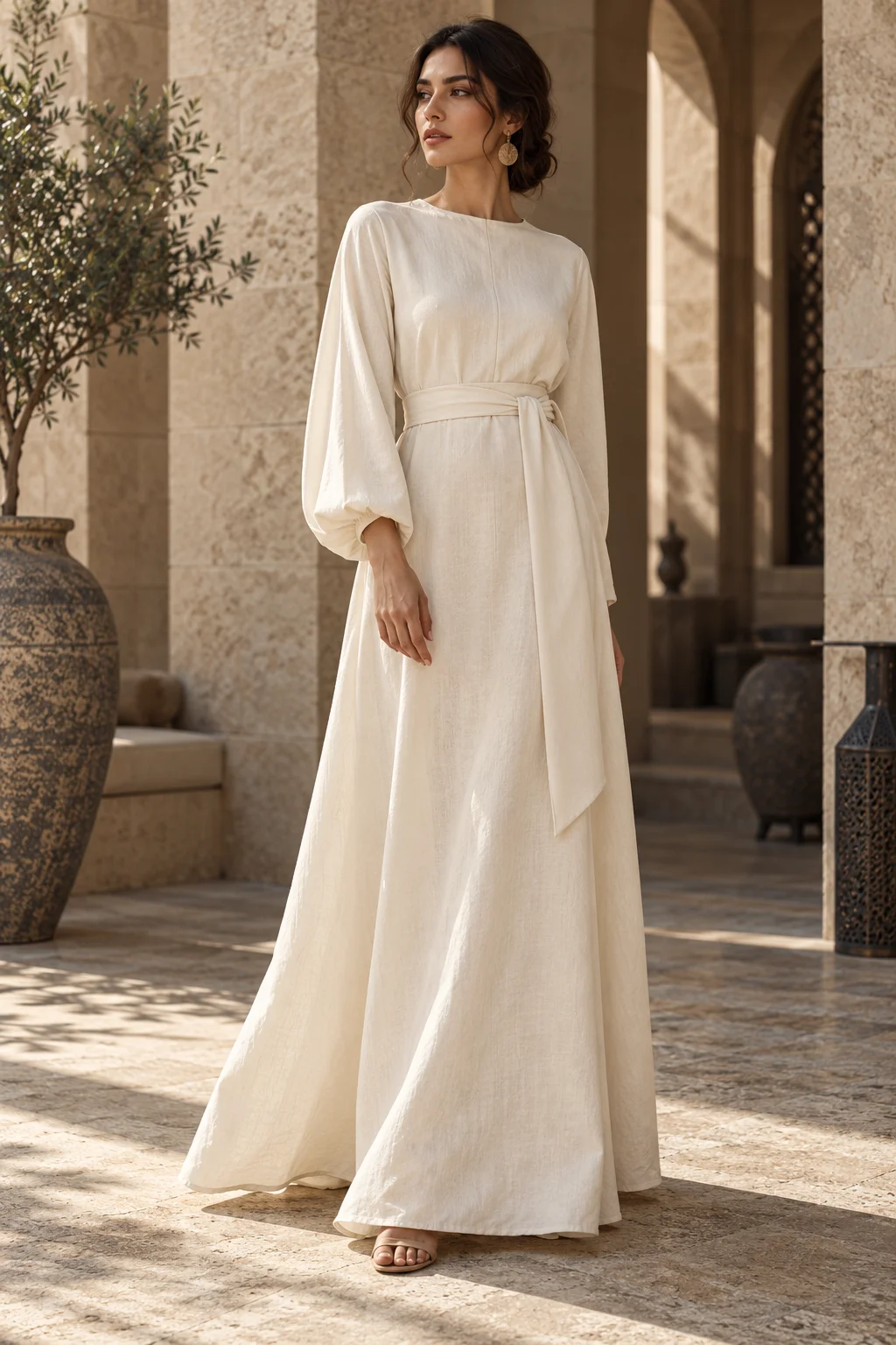 Representative womenswear: a flowing ivory ready-to-wear dress in a sandstone courtyard